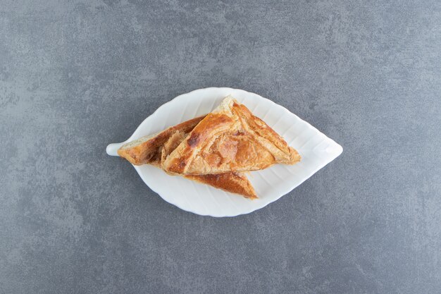 Dolci a forma di triangolo ripieni di formaggio sul piatto bianco.
