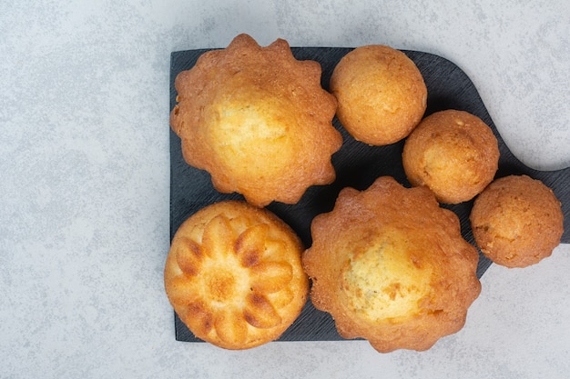 Dolci deliziosi pasticcini a bordo scuro.