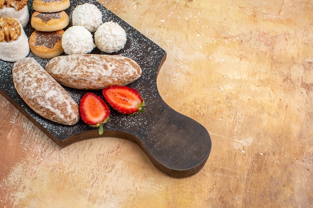 Dolci gustosi vista frontale con biscotti e confetture sulla torta torta dolce scrivania in legno