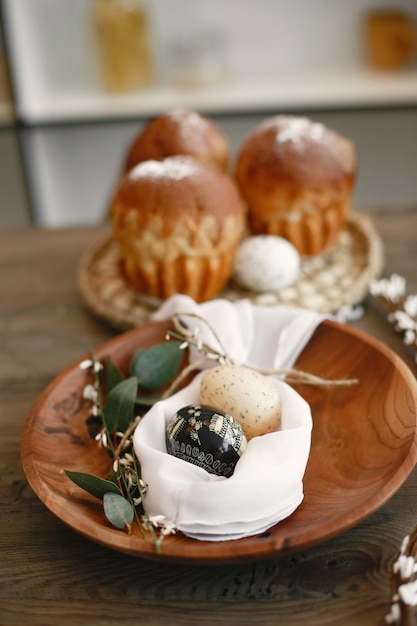 Dolci pasquali sul tavolo. Uova di Pasqua su un piatto di legno. Preparazione alla Pasqua.