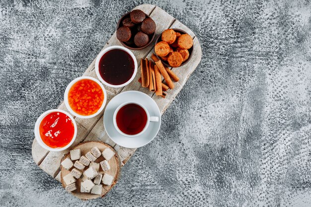 Dolci piatti con tè, cialde e gelatina in piatti e scodelle