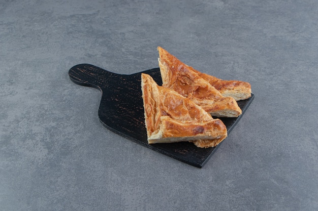 Dolci triangolari ripieni di formaggio su tavola di legno.