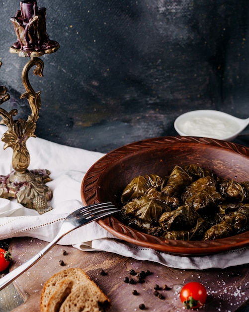 Dolma gustoso pasto di carne salata all'interno del piatto marrone sulla superficie scura