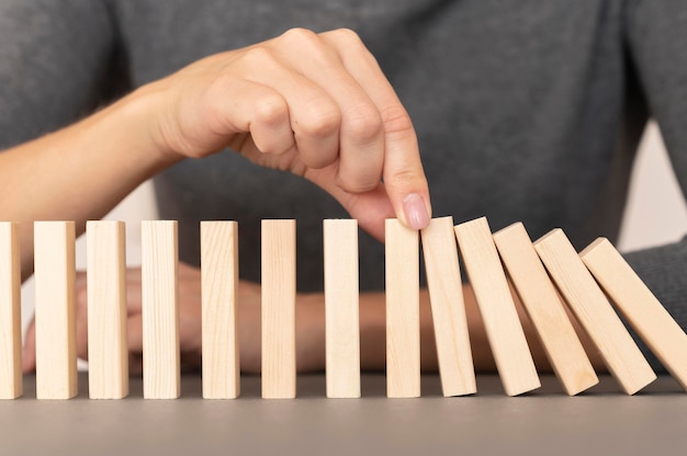 Domino realizzato con pezzi di legno che rappresentano le finanze