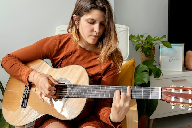 Donna a casa a suonare la chitarra