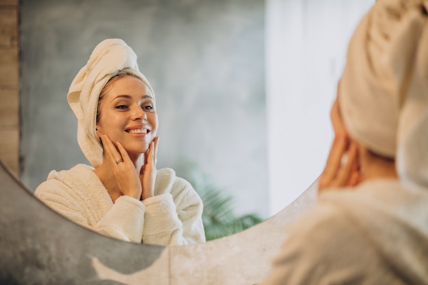 Donna a casa che applica la maschera crema