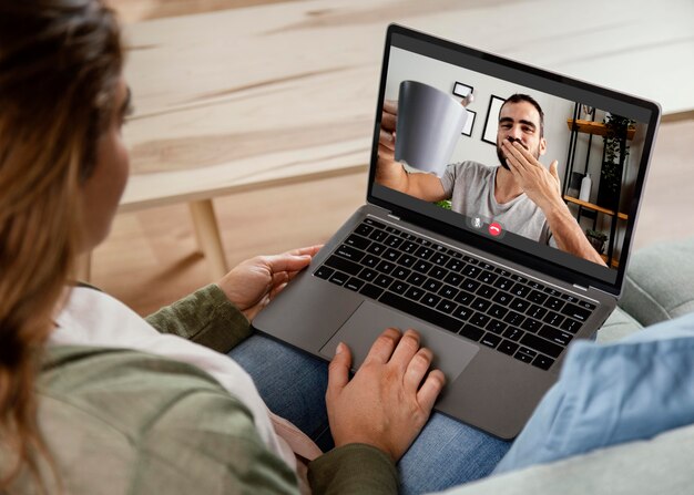 Donna a casa che ha videochiamata sul computer portatile