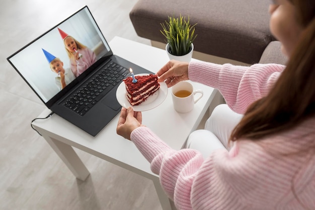 Donna a casa in quarantena con torta con un amico sul computer portatile