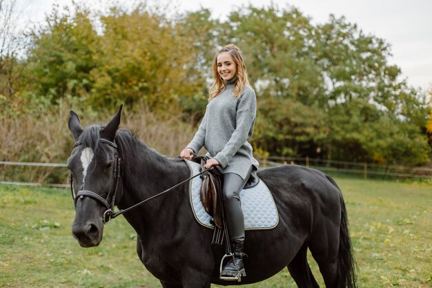 Donna a cavallo al rancho. Equitazione, tempo di hobby. Concetto di animali e umani