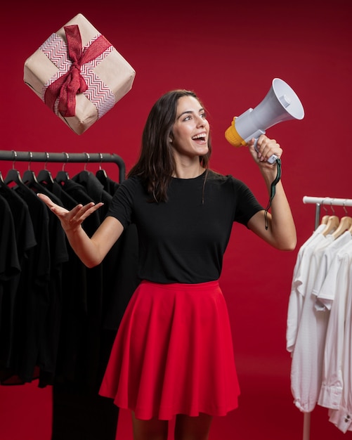 Donna a fare shopping gridando in un megafono mentre cattura un regalo