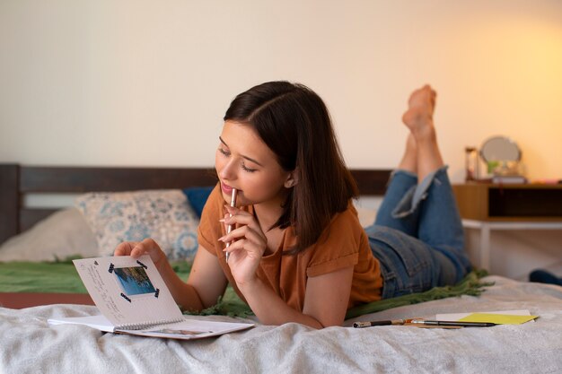 Donna a figura intera che fa l'inserimento nel diario creativo