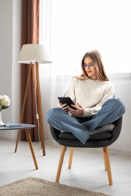 Donna a figura intera che legge rivista digitale