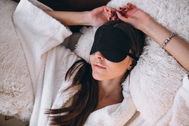 Donna a letto indossando la maschera di sonno