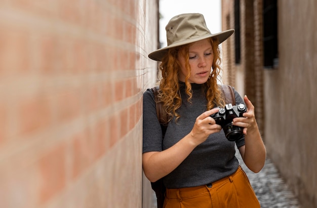 Donna a metà colpo con cappello che guarda l'obbiettivo