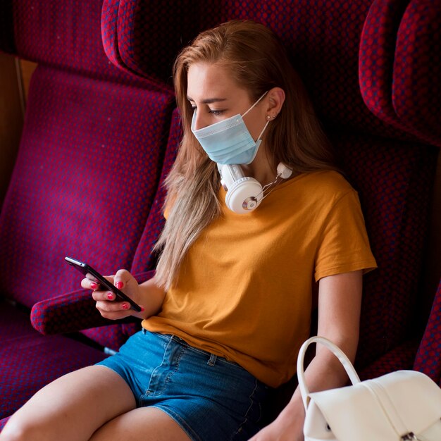 Donna a metà tiro con maschera in treno