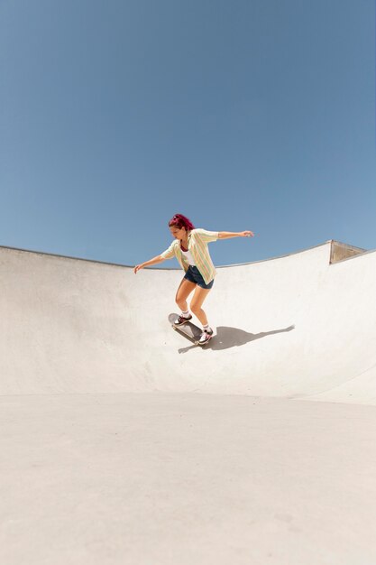 Donna a tiro lungo su skateboard all'esterno