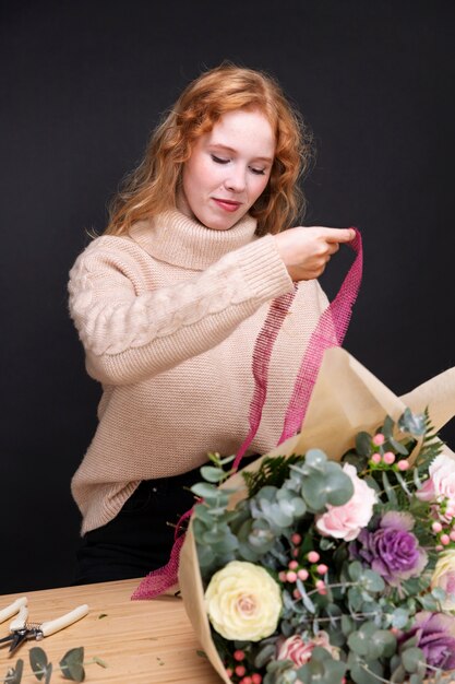 Donna a tiro medio che sistema il bouquet