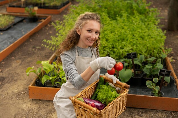 Donna a tiro medio con cesto di verdure