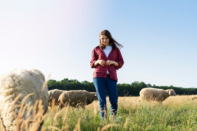 Donna a tutto campo che si prende cura delle pecore