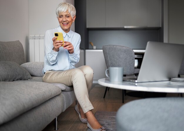 Donna a tutto campo che si prende una pausa con lo smartphone