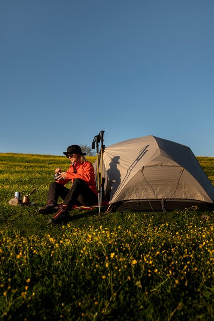 Donna a tutto campo seduta vicino alla tenda