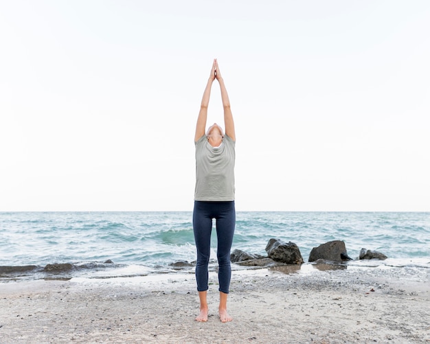 Donna abbastanza bionda a praticare yoga all'aperto