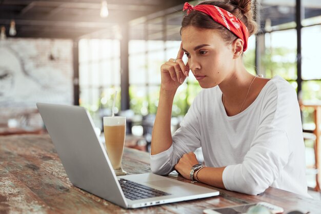 Donna abbastanza bionda che si siede nella caffetteria