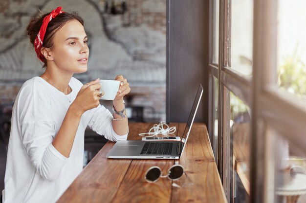 Donna abbastanza bionda che si siede nella caffetteria