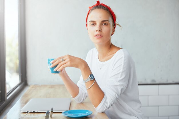 Donna abbastanza bionda che si siede nella caffetteria