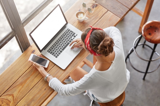 Donna abbastanza bionda che si siede nella vista superiore del caffè