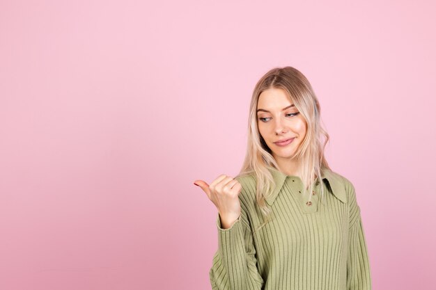 Donna abbastanza europea in maglione casual sulla parete rosa