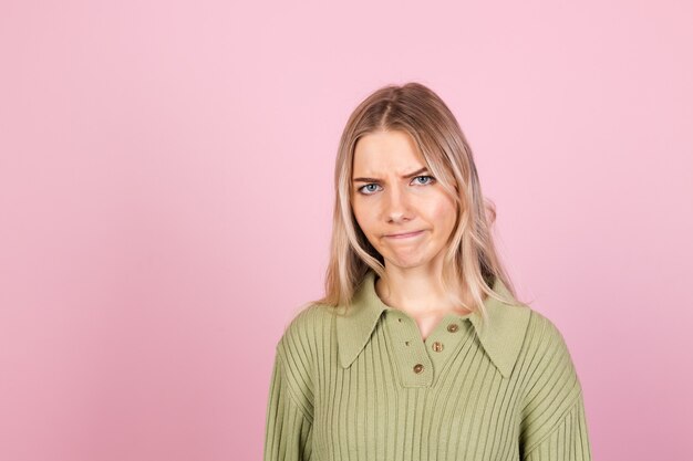 Donna abbastanza europea in maglione casual sulla parete rosa