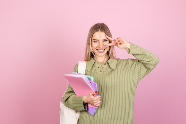 Donna abbastanza europea in maglione casual sulla parete rosa