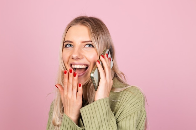 Donna abbastanza europea in maglione lavorato a maglia casual sulla parete rosa