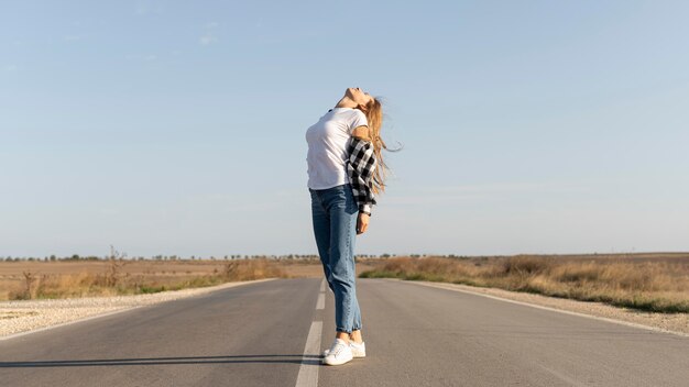 Donna abbastanza giovane che gode del viaggio su strada