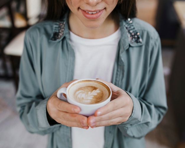 Donna abbastanza giovane che gode di una tazza di caffè