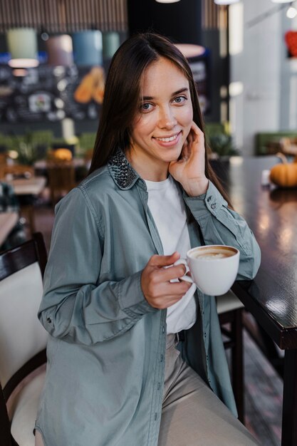 Donna abbastanza giovane che gode di una tazza di caffè