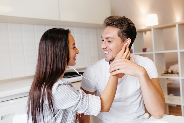 Donna abbronzata dai capelli neri che tiene il viso del marito mentre parla con lui