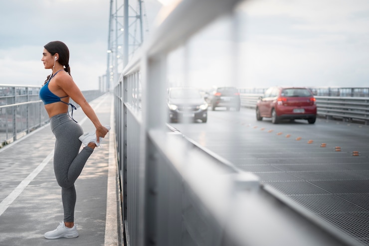 Foto gratuito donna adatta del colpo pieno che allunga all'aperto