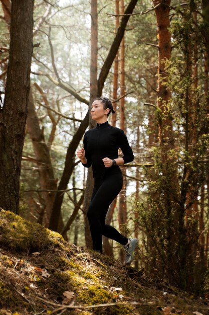 Donna adatta di vista laterale che corre nella natura