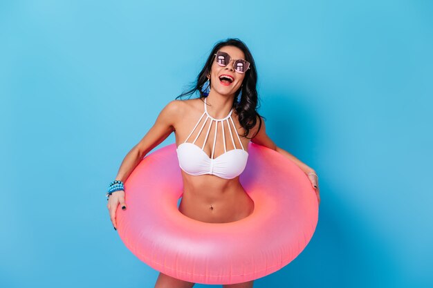 Donna adorabile che posa con il cerchio rosa di nuoto