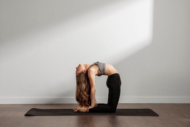 Donna adulta a praticare yoga a casa