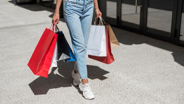 Donna adulta che trasportano borse della spesa colorate