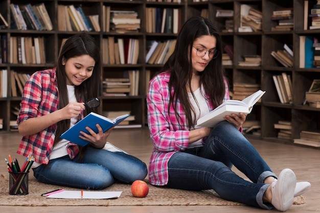 Donna adulta e ragazza che leggono insieme