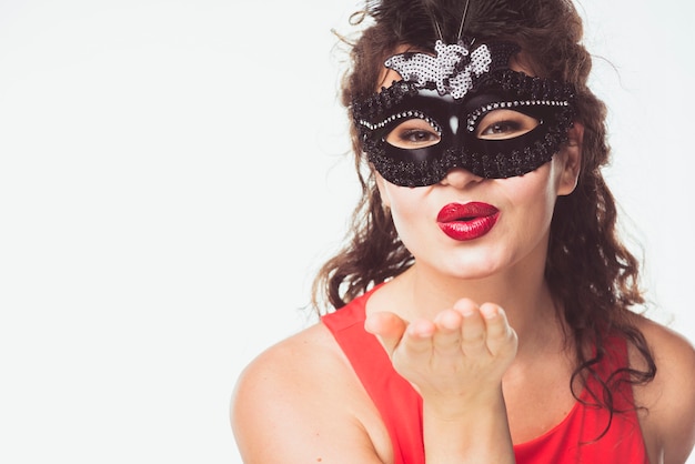 Donna adulta in maschera che invia bacio d&#39;aria