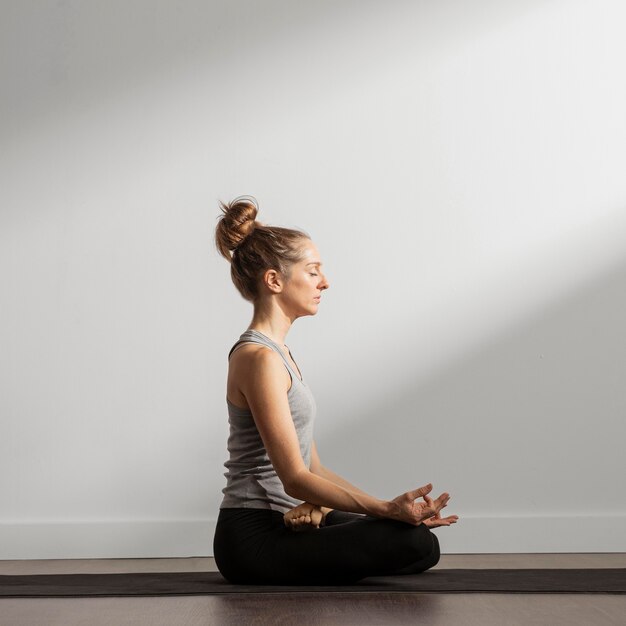 Donna adulta meditando a casa