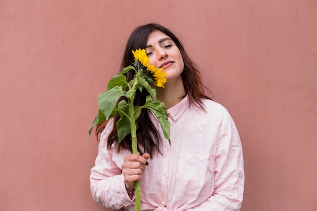 Donna affascinante con girasole in fiore