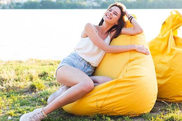 Donna affascinante di vista frontale che posa sul beanbag