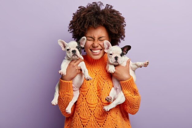 Donna afro-americana che indossa i cuccioli di azienda maglione arancione