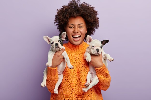 Donna afro-americana che indossa i cuccioli di azienda maglione arancione